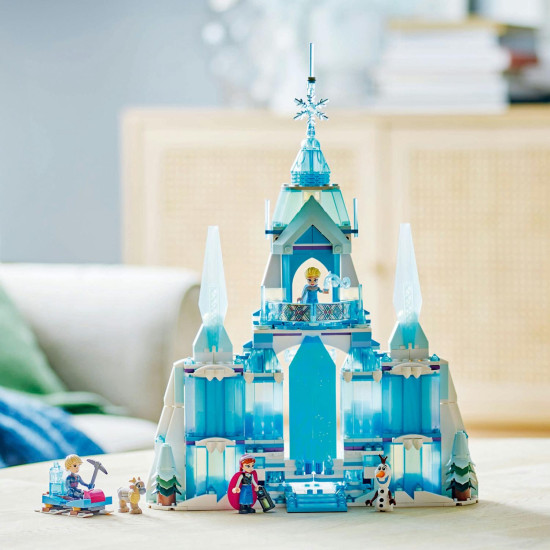 Trojposchodový ľadový palác Elsy z LEGO® Ľadového kráľovstva so scénou, kde Elsa, Anna a Kristoff stoja na balkóne, s pohyblivou podlahou, kúzelnými dverami a padajúcim lustrom. 