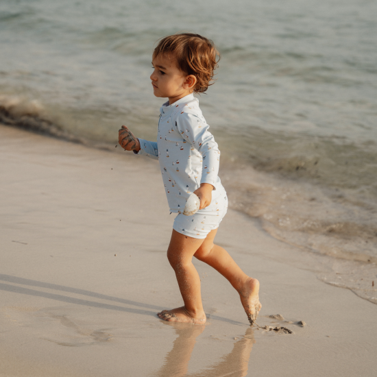 Plavecké tričko z UV ochrannej tkaniny s krásnou potlačou námorníckeho zálivu chráni vaše dieťa pred slnkom pri kúpaní pri mori aj doma na záhrade. 