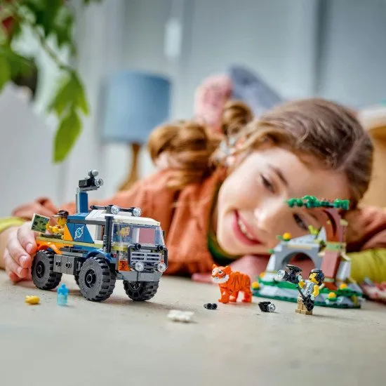 LEGO CITY terénne vozidlo s robustnými pneumatikami a ramenom s fotoaparátom, prieskumníci v džungli sledujú tigra, doplnené o ďalekohľad, vysielačku, mapu a prieskumný dron pre dobrodružný prieskum.