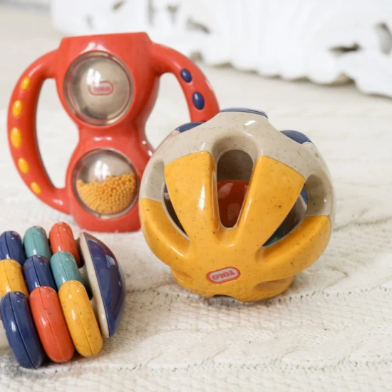 Farebná hrkálka v tvare guličky s otvormi pre jednoduché uchopenie do rúk bábätka